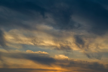The sky at sunset. Cumulus clouds lit by the rays of the setting sun.