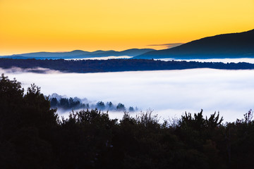 Early morning sunrise of a fog enshrouded valley, Stowe, Vermont, USA