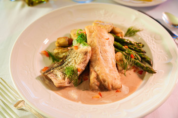 Sea bass dinner on a white plate.