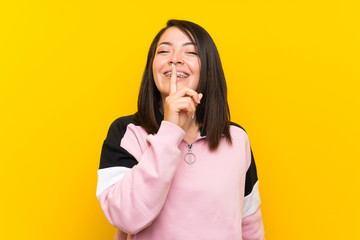 Young Mexican woman over isolated yellow background doing silence gesture