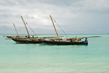 Fototapeta na wymiar Tanzania, Zanzibar, Nungwi, traditional fisherman boat on white beach