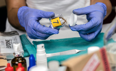Specialist cop examines hair from crime scene, conceptual image
