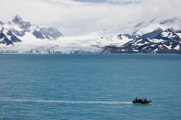 Antarctica, South Georgia, Royal Bay. A zodiac cruises in front of Ross Glacier. 