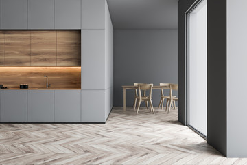 Gray kitchen with countertops and wooden table