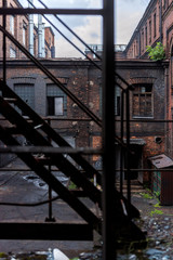 Fototapeta premium View through the stairs to the building of the old factory