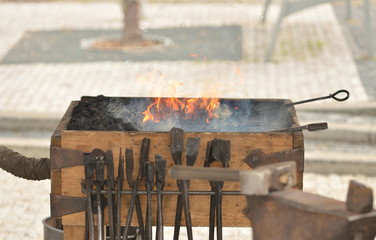 Blacksmith s forge with flames and iron tools