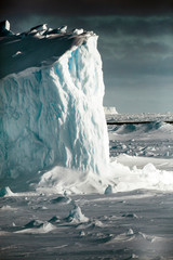 Antarctica. Iceberg at sunrise surrounded by sea ice. © Janet Muir/Danita Delimont