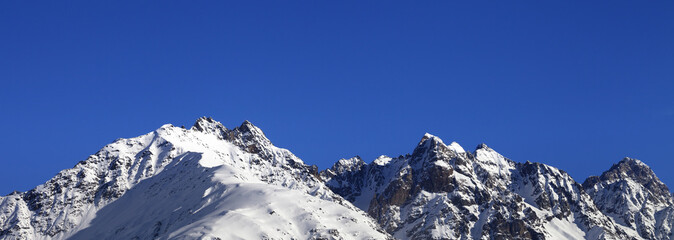 Fototapeta na wymiar Snowy rocks and blue clear sky at nice winter day