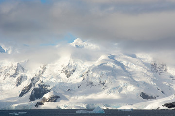 Fototapeta na wymiar Antarctica. Paradise Harbor. Snowy mountains and clouds.