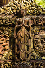 Fototapeta na wymiar Myanmar. Mandalay. Sagaing Hill. Detail of a tiny carved teak temple hidden in the woods.