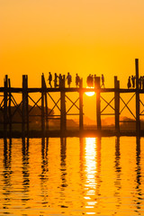 Myanmar. Mandalay. Amarapura. U Bein Bridge. Tourists walking on the bridge at sunset.