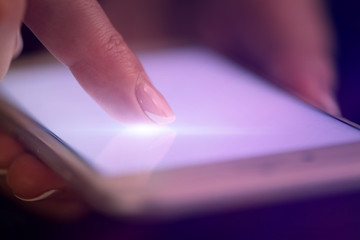 Finger touching phone with dark background with copyspace