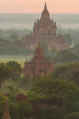 Myanmar. Bagan. Smoke from cooking fires shrouds the temples of Bagan at sunrise.