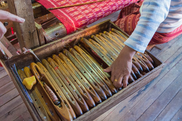 Myanmar. Shan State. Inle Lake. Ko Than Hlaing silk and lotus weaving center. Woman weaving silk at a wooden loom.