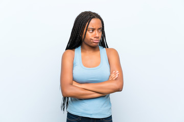 African American teenager girl with long braided hair over isolated blue background thinking an idea