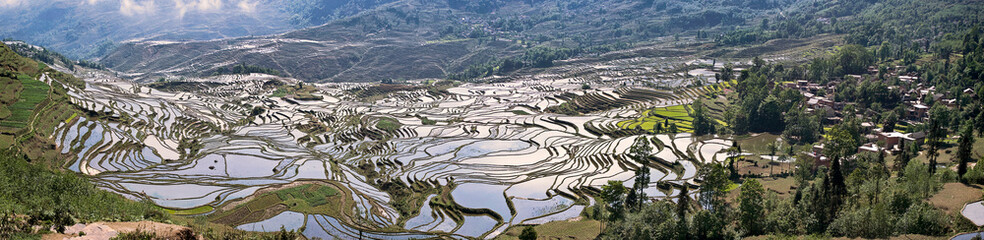 Asia, China, Yunnan Province, Yuanyang County. Village and flooded Ai Cun rice terraces.