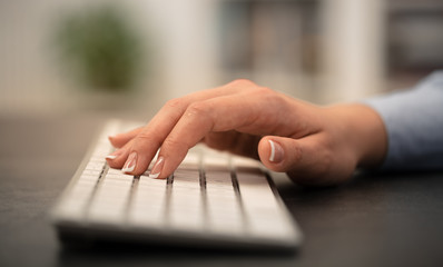 Hand typing on keyboard with office concept