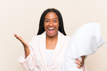 African American teenager girl with long braided hair in pajamas over isolated background with...