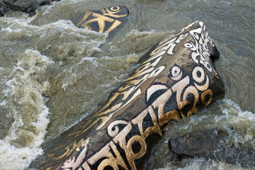 Rocks painted with prayer words in the river, Tagong, western Sichuan, China