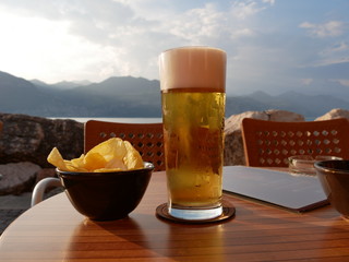 glass of beer and chips on wooden table