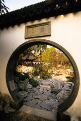 View of Yuyuan Gardens through the circular door in a traditional Chinese wall in Shanghai People's Republic of China