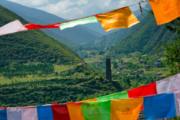Songgang Tibetan houses and watch tower with praying flags in the mountain, Ngawa Tibetan and Qiang Autonomous Prefecture, western Sichuan, China