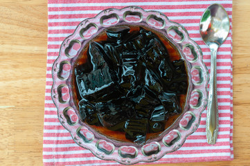 Glass jelly serve in crystal glass bowl on red strip napkin.  Glass jelly is a popular dessert in summer season, refreshing cool down.