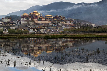 Asia, China, Yunnan Province, Shangri-la, Songzanlin Monastery. The monastery at dawn reflected in the sacred lake.