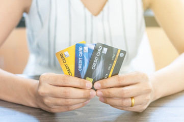 Unidentified woman in white dress holding credit card, personal financial credit, use credit cards instead of cash for manage the cash flow.