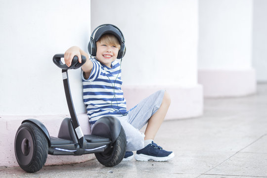 Smiling child riding segway. Active youth. Cute boy outdoors with electric rover.