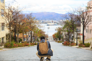 Hachiman-zaka slope in Hakodate Hokkaido Japan, One of famous place in Japan. A man sitting on street and looking far away.