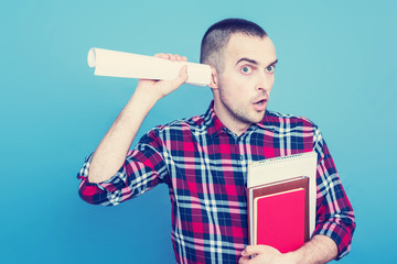 Student with books, guy eavesdropping, portrait, blue background, copy space, slogan, toned