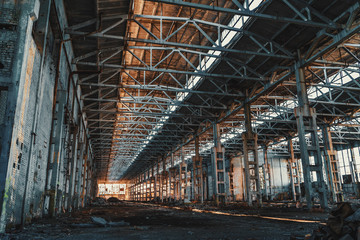 Ruined and abandoned industrial factory warehouse hangar with perspective view