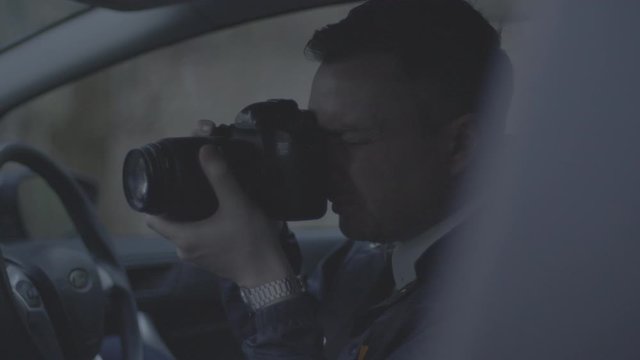 Police officer in car taking photos