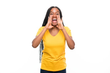 African American teenager girl with long braided hair over isolated white background shouting with mouth wide open