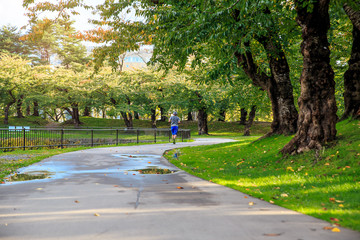 Healthy of asian sport man jogging in the park. Runner enjoying at sunset in the garden while running on day off. Concept of Relaxation, Sport and Healthy concepts.