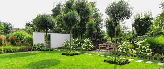 Foto op Plexiglas Prachtige tuin met een houten bankje © Beenis
