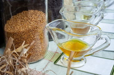 Mustard seeds in jar and oil pressed from them.