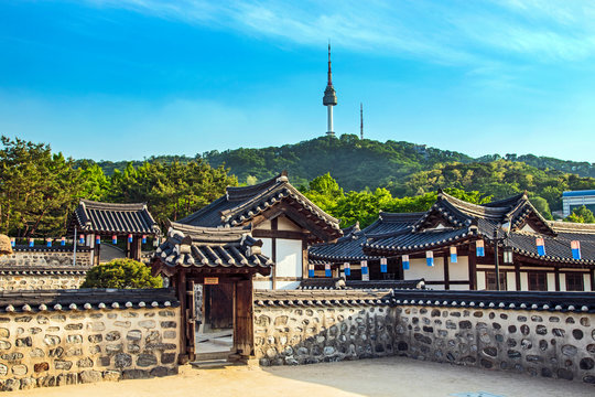 Seoul, South Korea. Traditional Korean village courtyard of Namsangol Hanok with the YTN Seoul Tower (Namsan Tower or Seoul Tower) in the background.