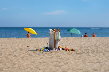 Garbage bags on the sea coast. Garbage in sand beach. Dumpsters bag full with garbage. Recreational waste baskets on beach.