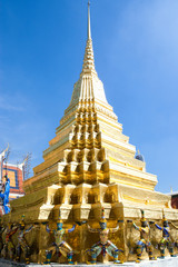 Bangkok, Thailand - Golden statues are holding a golden tiered building over their head. The tiered...