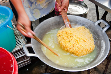 Bangkok, Thailand - Thai noodles are being cooked at an outdoor vendor on the street.