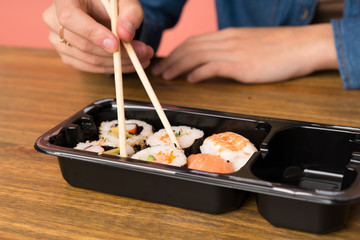 Young blonde woman eating sushi