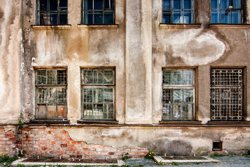 Fototapeta na wymiar Wall with broken windows of abandoned building