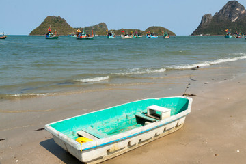 Fototapeta na wymiar Thailand, Prachuap Khiri Khan. Ao Manao beach. Small colorful rowboats pulled up on the beach.