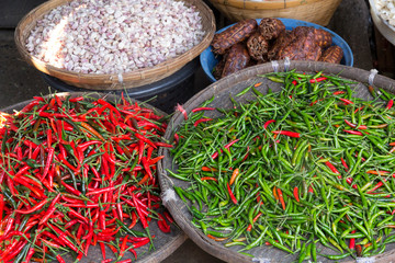 Thailand, Chiang Mai. Thai street vendor of green and red Chilies.