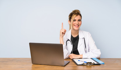 Blonde doctor woman showing and lifting a finger in sign of the best