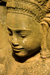 Fototapeta na wymiar Cambodia. Siem Reap. Angkor Thom. Carved diety on a temple wall.