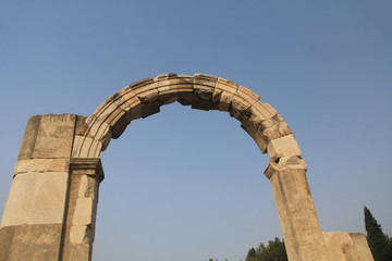 Obraz premium Doorway arch along the Marble Road in the ancient city ruins of Ephesus, Turkey near Selcuk with blue sky copy space.