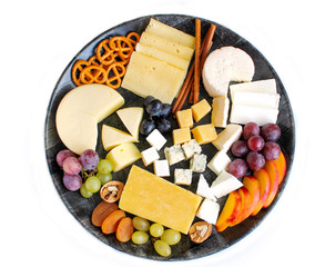 Rustic cheese platter with different cheese and grapes